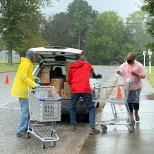 volunteers loading bags of food into a car